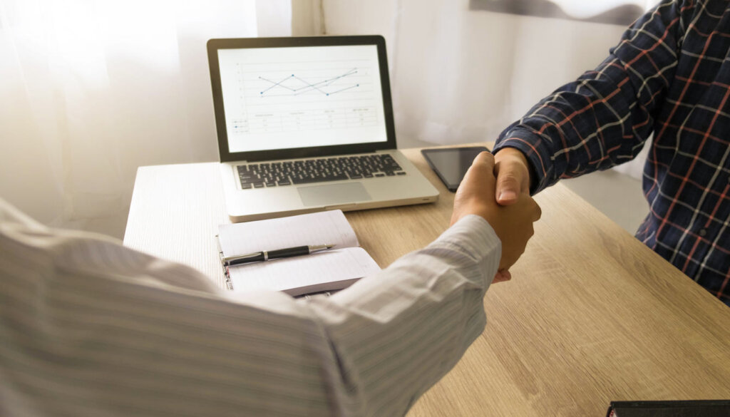 Parceria de crescimento: aperto de mãos entre executivos simbolizando a colaboração estratégica com uma agência de SEO de alto nível
